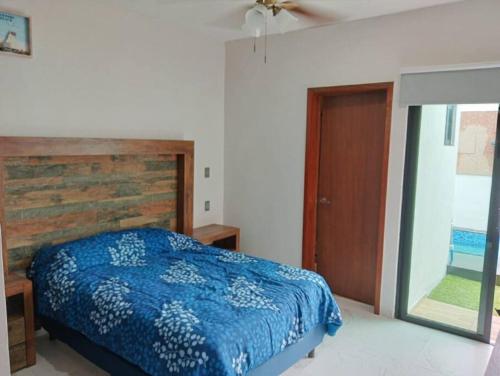 a bedroom with a blue bed and a wooden headboard at Hermosa Residencia junto al mar in Veracruz