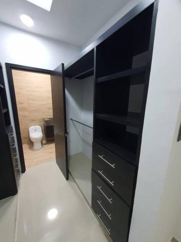 a bathroom with a black cabinet and a toilet at Hermosa Residencia junto al mar in Veracruz