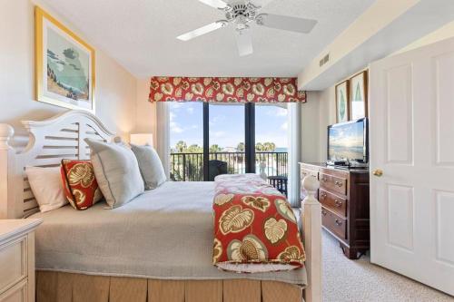 a bedroom with a bed and a window with a balcony at Captain's Quarters Upscale 3 Bedroom Condo in Pawleys Island