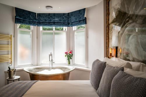 een slaapkamer met een bad in een raam bij Icon - FREE off-site Health Club access with Pool, Sauna, Steam Room & Gym in Windermere