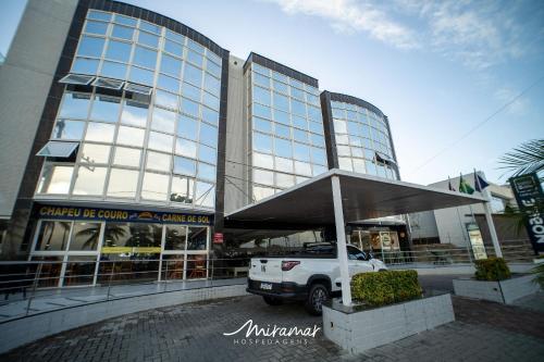a white truck parked in front of a building at Imperial Nobile in Tambaú