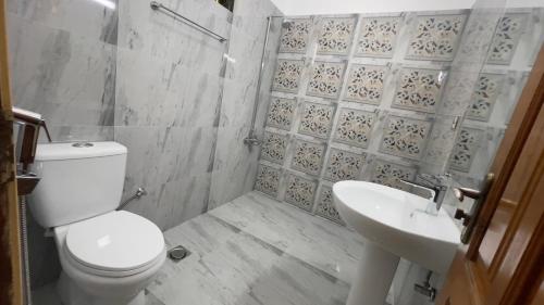 a bathroom with a toilet and a sink at Midways Guest House and Hotels in Islamabad