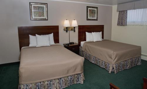 a hotel room with two beds and two lamps at Travelers Inn in Brunswick