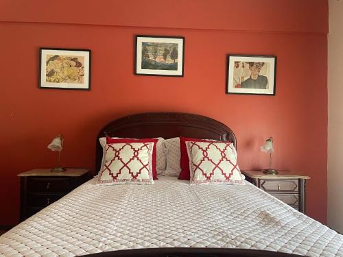 a bedroom with a bed with red walls at Cozy apartment near Parque das Nações in Bobadela