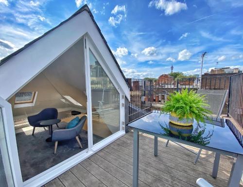 een balkon met een glazen tafel en stoelen op een dak bij Soho Penthouse by Concept Apartments in Londen