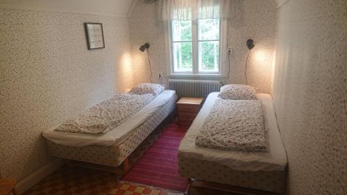 two beds in a room with a window at Lekvattnet 129 in Torsby