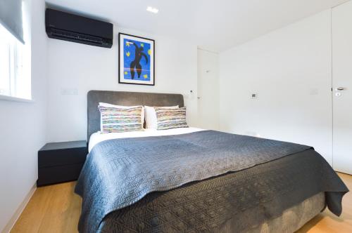 a bedroom with a large bed with a tv on the wall at Soho Penthouse by Concept Apartments in London