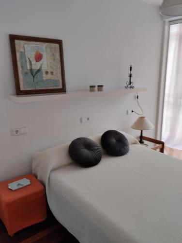 um quarto com uma cama com duas almofadas pretas em ALVAFER em Ribadeo