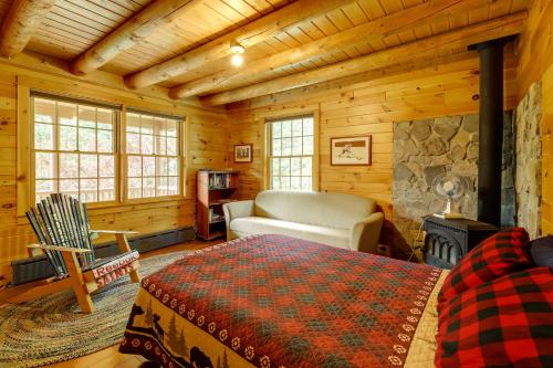 Dormitorio en cabaña de madera con cama y chimenea en Stellar Wilmington House on 20 Wooded ADK Acres!, en Wilmington