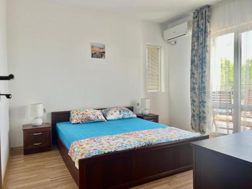 een slaapkamer met een bed met blauwe lakens en een raam bij Vista Sul Mare III 
