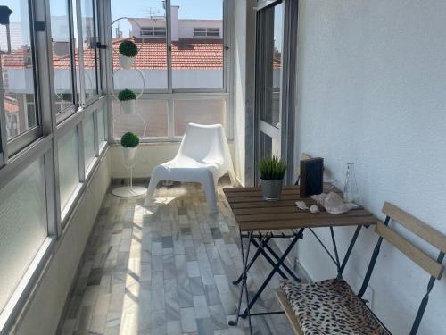 a balcony with a table and two white chairs at Cozy apartment near Parque das Nações in Bobadela