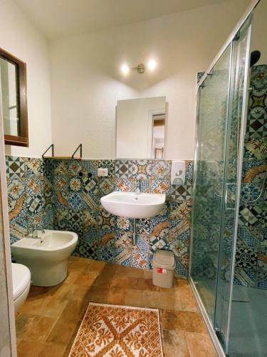 a bathroom with a sink and a shower at LOFT CON USO CUCINA E TERRAZZO PANORAMICO - FORA E' MUROS II - Ammentos Posada in Posada