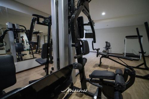 a gym with several tread machines in a room at Imperial Nobile in Tambaú