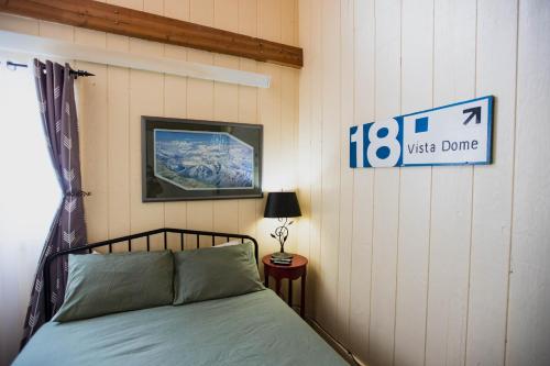 a bedroom with a bed and a sign on the wall at The Viking Lodge - Downtown Winter Park Colorado in Winter Park