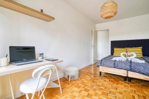 a bedroom with a bed and a desk with a laptop at Rubis luxe proche Paris in Choisy-le-Roi