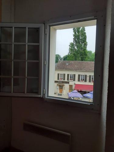 une fenêtre avec vue sur un bâtiment dans l'établissement appartement 2 chambres à Lésigny, à Lésigny