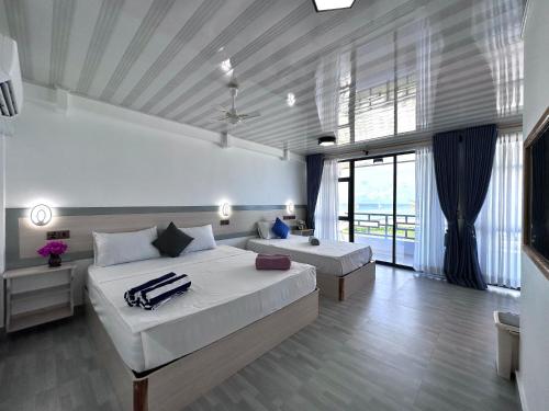 a bedroom with two beds and a large window at Galaxy Sunrise Sea View in Fulidhoo