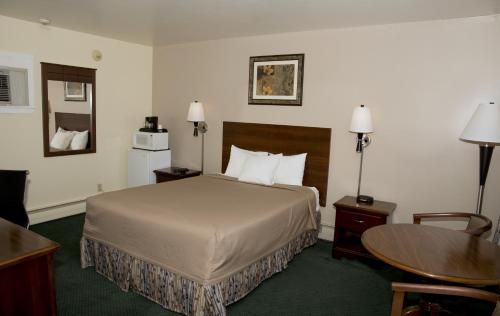 a hotel room with a bed and a table at Travelers Inn in Brunswick