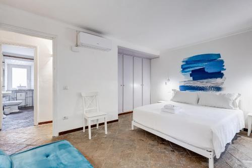 1 dormitorio con 1 cama blanca y una pintura azul en la pared en BMGA l Magic Tiber 2Bdr Close to Piazza Navona, en Roma