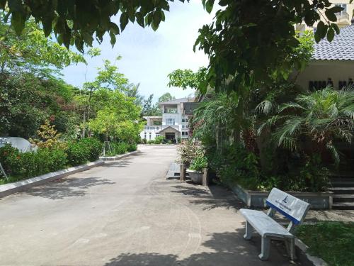 une rue vide avec un banc devant un bâtiment dans l'établissement Nha Khach Hai Quan, à Đồ Sơn