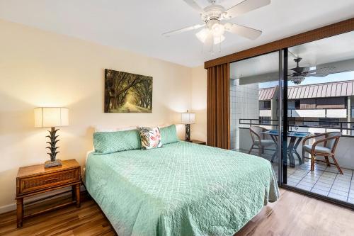 - une chambre avec un lit et un balcon avec une table dans l'établissement White Sands Village 223, à Kailua-Kona
