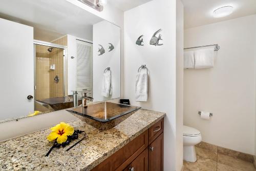 La salle de bains est pourvue d'un lavabo et de toilettes. dans l'établissement White Sands Village 223, à Kailua-Kona