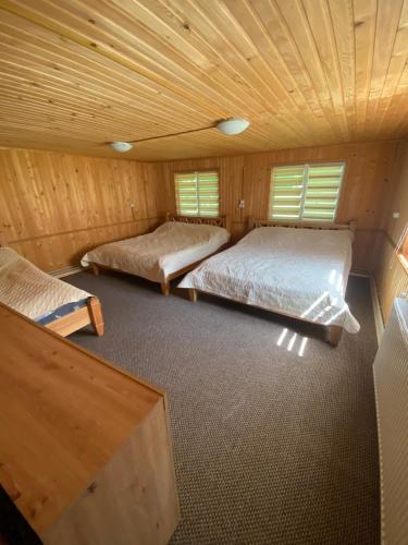 Duas camas num quarto com tecto em madeira em Солонець em Chereshenka