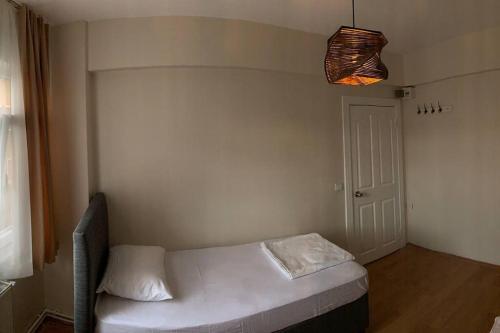 - une petite chambre avec un lit blanc et une lumière dans l'établissement Your comfort place in Beşiktaş, à Istanbul