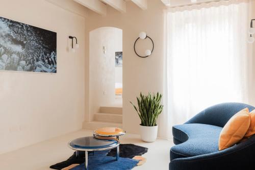 ein Wohnzimmer mit einem blauen Stuhl und einem Tisch in der Unterkunft Palazzo Mazzini in Como