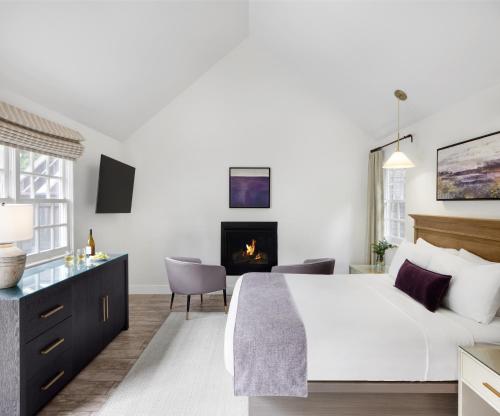 a bedroom with a king sized bed and a fireplace at Lavender, A Four Sisters Inn in Yountville