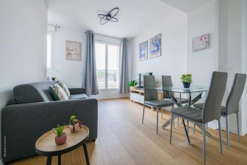 een woonkamer met een bank en een tafel bij Cosy Appart Proche Paris in Montreuil