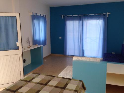 Habitación con paredes azules y cortinas azules. en Maio Relax, en Vila do Maio