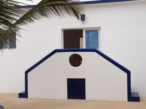 una pequeña casa blanca con una puerta negra en Maio Relax, en Vila do Maio