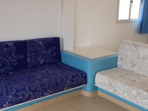 a blue couch and a chair in a room at Maio Relax in Vila do Porto