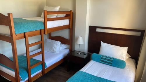 Cette petite chambre comprend deux lits superposés et un lit. dans l'établissement Hotel y Departamentos La Serena - Caja Los Andes, à La Serena