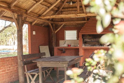 una cocina al aire libre con mesa de madera y barra en La Baguala del Candil, Casa Rural, Pileta y Parque en Solís