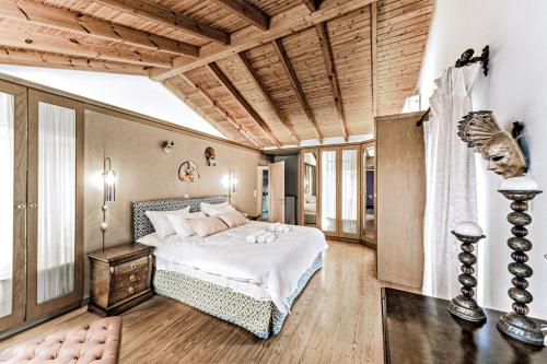 1 dormitorio con 1 cama grande y techo de madera en Casa dei fiori, en Mantoúkion