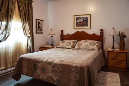 a bedroom with a bed and two lamps and a window at Maison sur la plage in Chambord