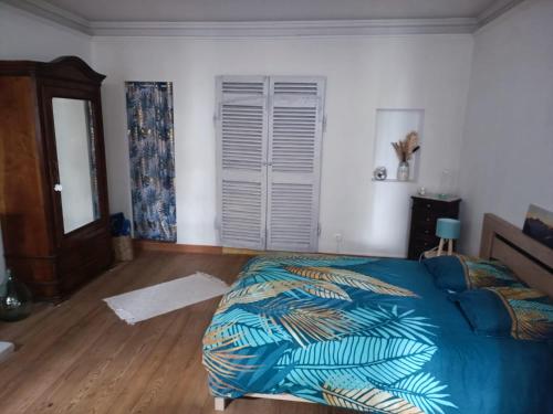 a bedroom with a bed with a blue comforter at L'écrin in Lacroisille