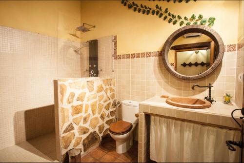 y baño con aseo, lavabo y espejo. en Apartamentos Las Abuelas, en Helechosa