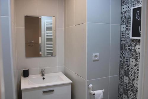 La salle de bains blanche est pourvue d'un lavabo et d'un miroir. dans l'établissement studio avec terrasse port de hyeres, à Hyères