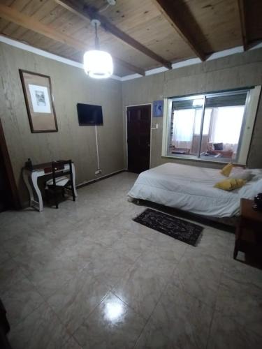 - une chambre avec un lit, un bureau et une télévision dans l'établissement CASA ANGELITA en SAAVEDRA, à Buenos Aires
