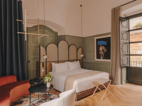 ジローナにあるHotel Palau Fugitのベッドルーム1室(ベッド1台付)、リビングルームが備わります。