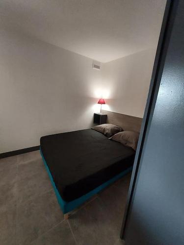 - une chambre avec un lit et une lampe dans l'établissement Logement Coquelicot, à Saint-Cyprien
