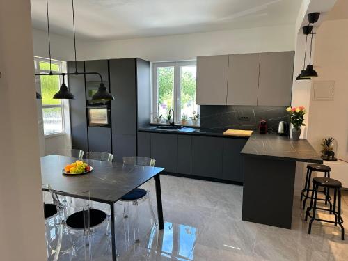 a kitchen with black cabinets and a table and chairs at Iris apartment in Vižinada