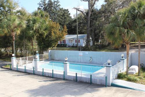 a swimming pool with a white fence around it at Travelers Inn Gainesville in Gainesville