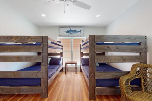 two bunk beds in a room with a chair at Sunset Bay in Dauphin Island