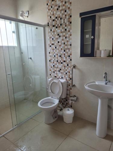 a bathroom with a toilet and a sink and a shower at Vó Paulina suites in Penha