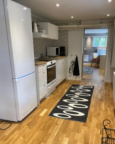cocina con nevera blanca y alfombra de cocina en Holiday Apartment, Bergåsa en Karlskrona