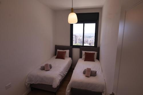 A bed or beds in a room at Beautiful 2BR near Mahane Yehuda